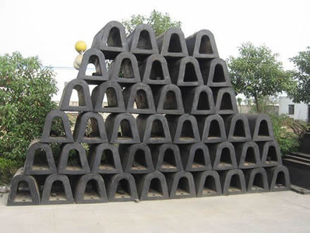 Several black MD rubber fenders are placed in the factory