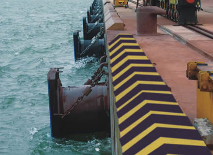 Rubber cell fenders are mounted on the dock.